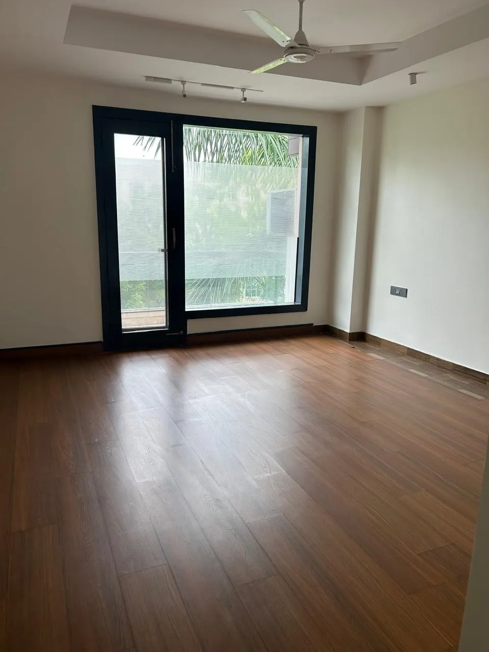 Bedroom with wooden flooring and garden-facing sliding doors
