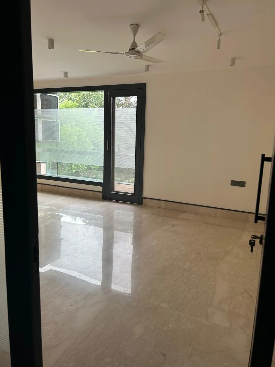 Bedroom with marble flooring opening onto the balcony