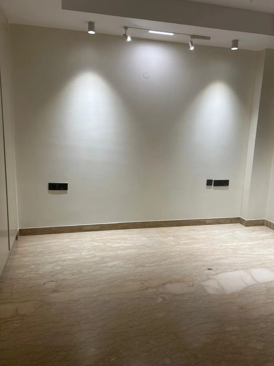 Bedroom with track lighting and marble flooring