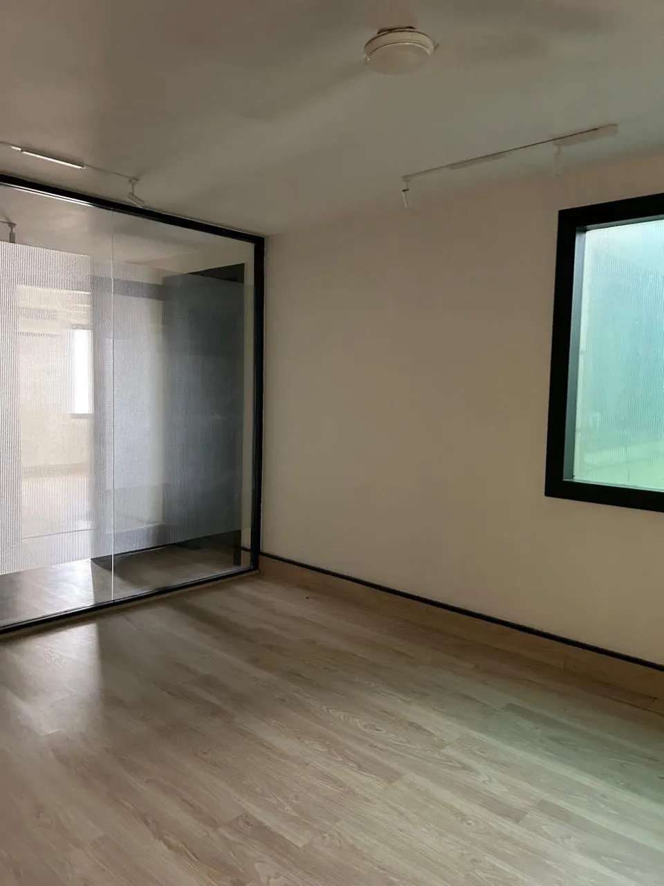 Room with a glass partition and wooden flooring